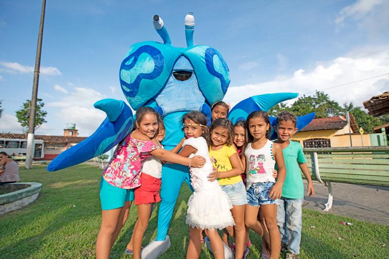 Local kids with a crab mascot during a campaign launch event in Caeté.