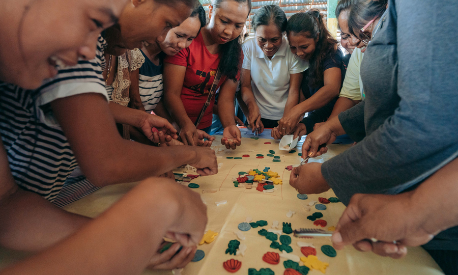 Community members playing the fish game at a Community Building Seminar hosted by Rare.