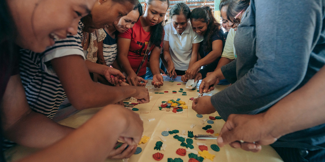 Community members playing the fish game at a Community Building Seminar hosted by Rare.