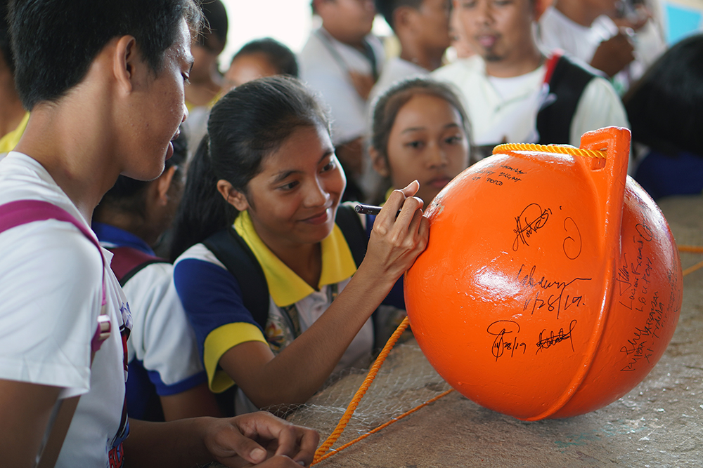 Poro student signing buoy.