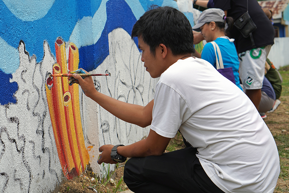 Poro art teacher painting an underwater mural.