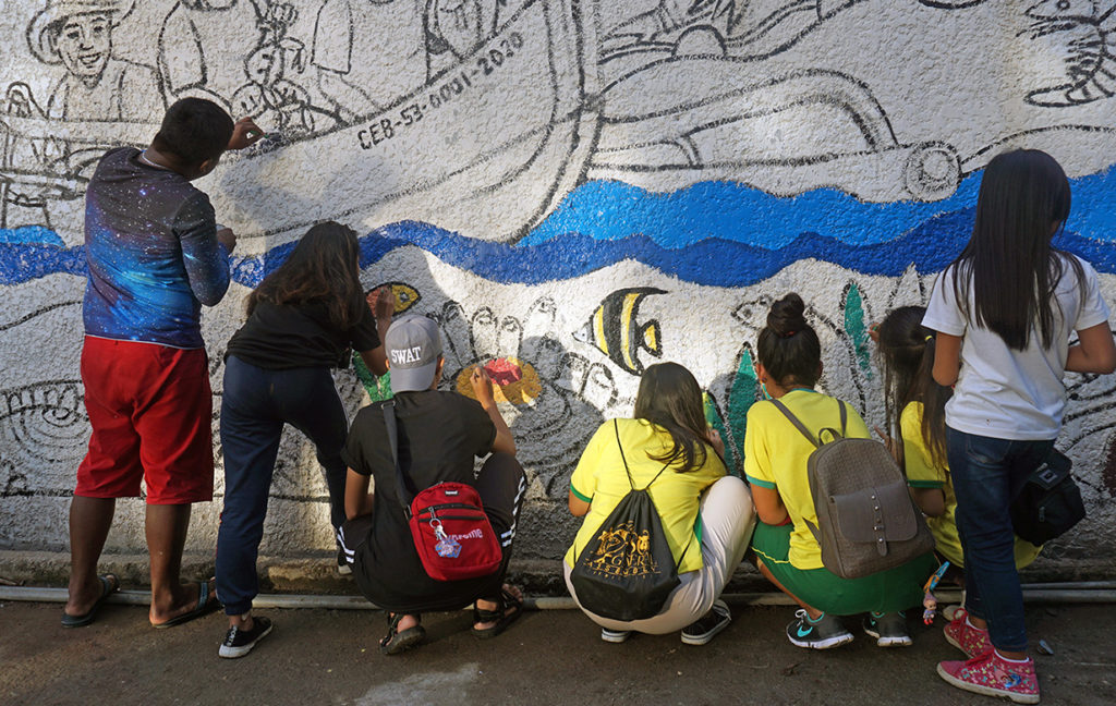 Group of youth painting a mural.