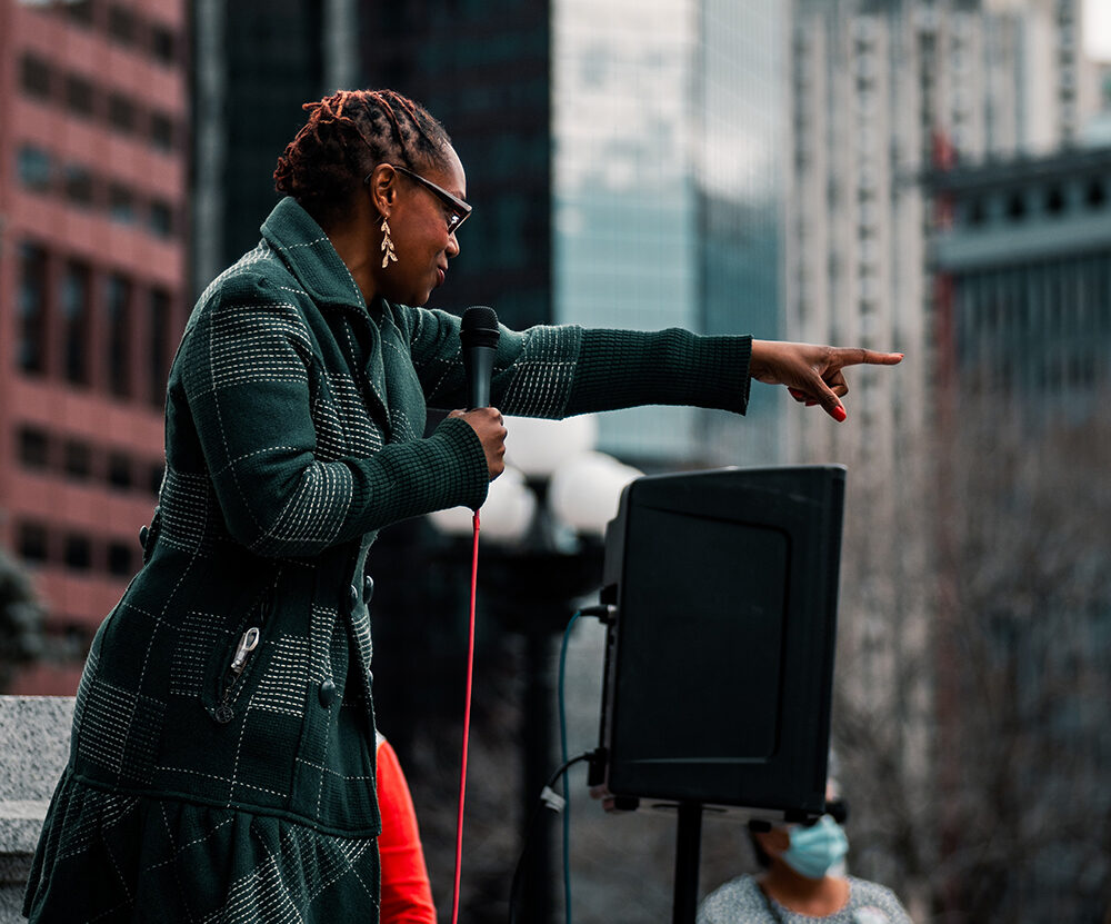 Black woman speaking at a rally in Denver, CO