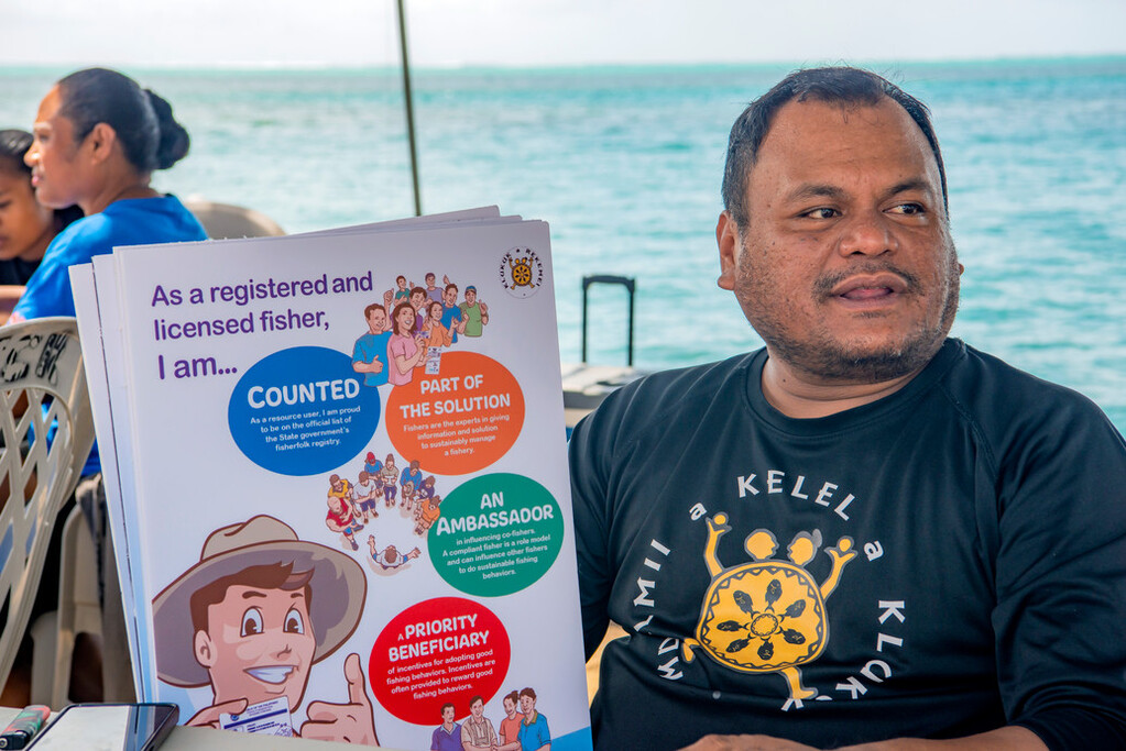 Rare's Kevin Mesebeluu, Program Implementation Manager (PIM) for Palau, speaking with local fishers about being registered.