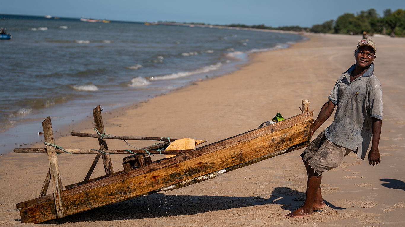 A Fisher pulling his boat to shore in Mozambique.