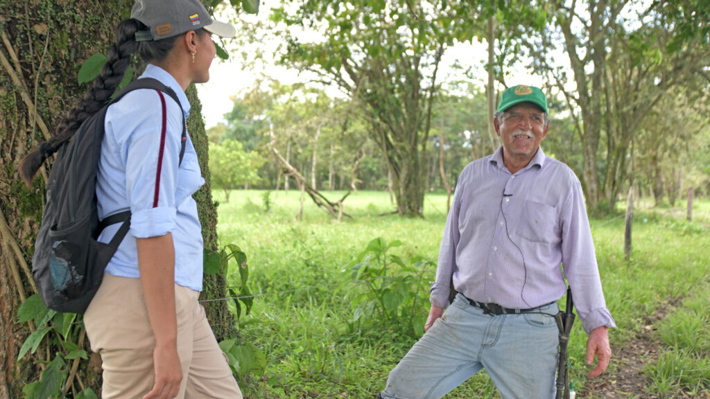 Clemente Burgos, a cacao, citrus, and livestock farmer at El Porvenir farm in the El Dorado community of Meta, Colombia speaking with Eliana Ardila, Rare's extension agent and technical assistant in the field.