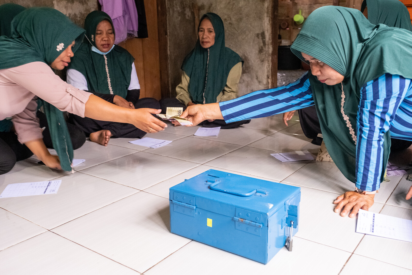 Women exchanging money during a savings club meeting in Indonesia.