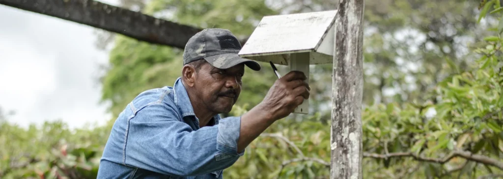 Farmer checking his agroclimatic station to measure rainfall.