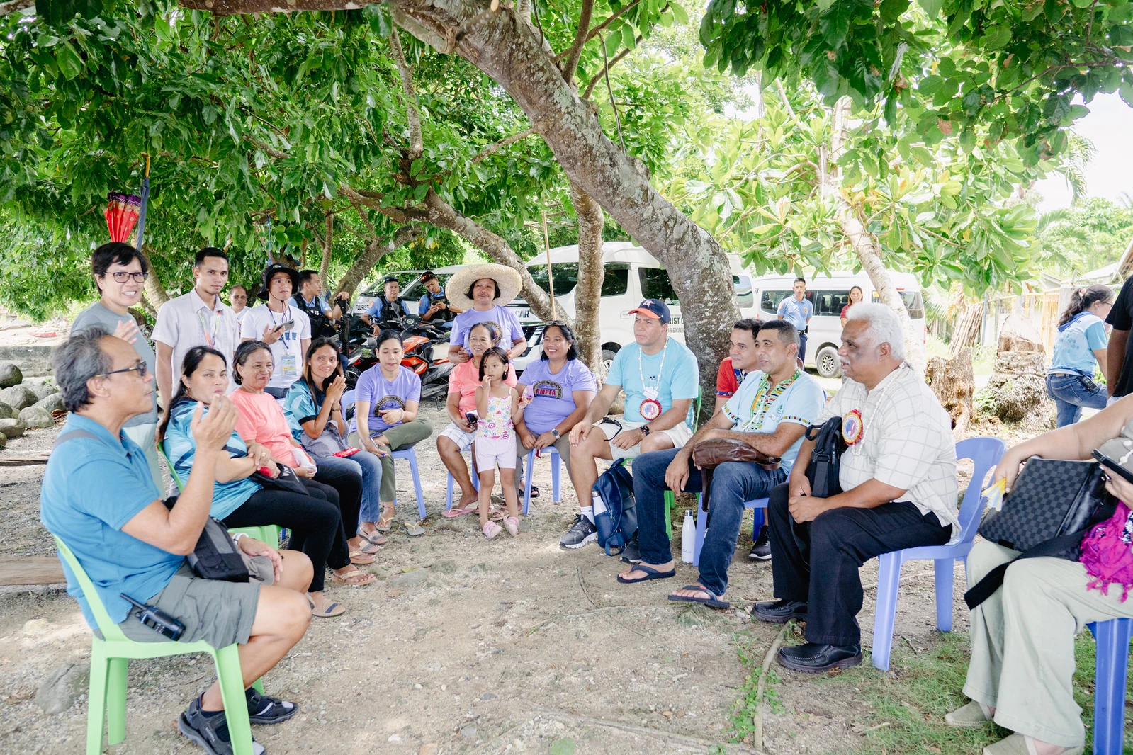 People in a small community sitting and talking in a semi-circle.