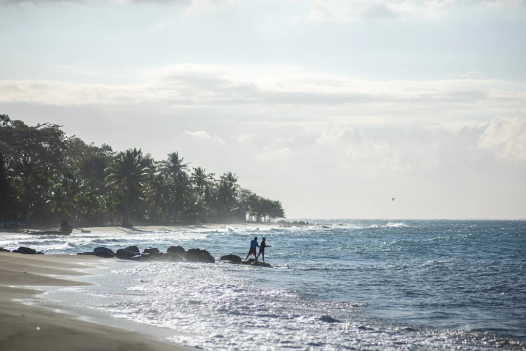 two fishers in the background on a beach