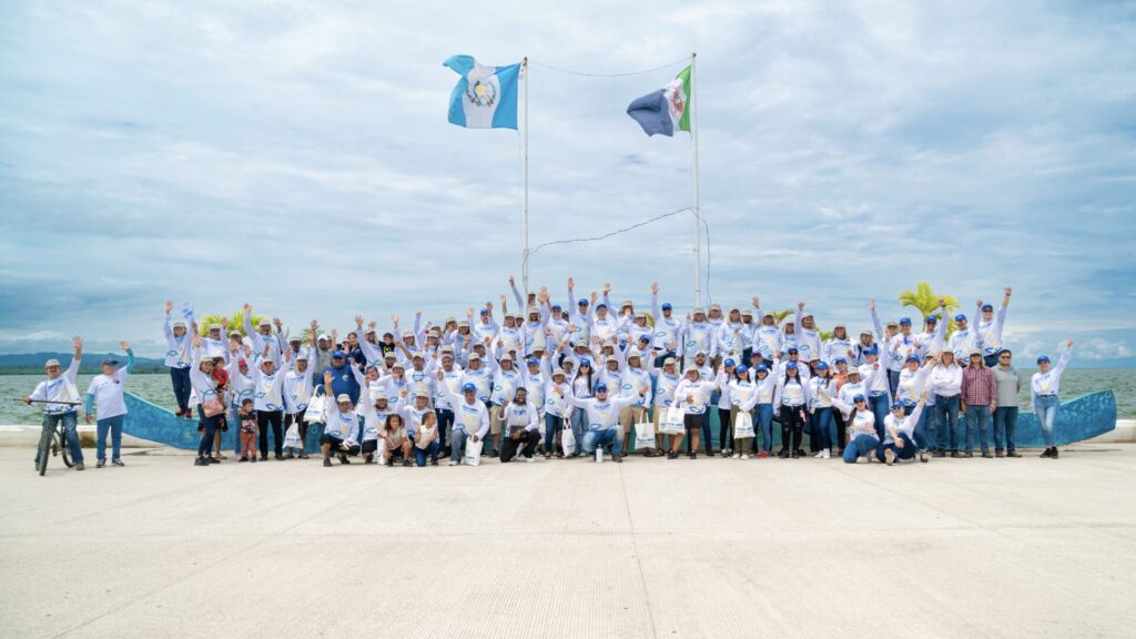a group of fishers wearing white shirts and hats with their arms raised in a celebratory manner
