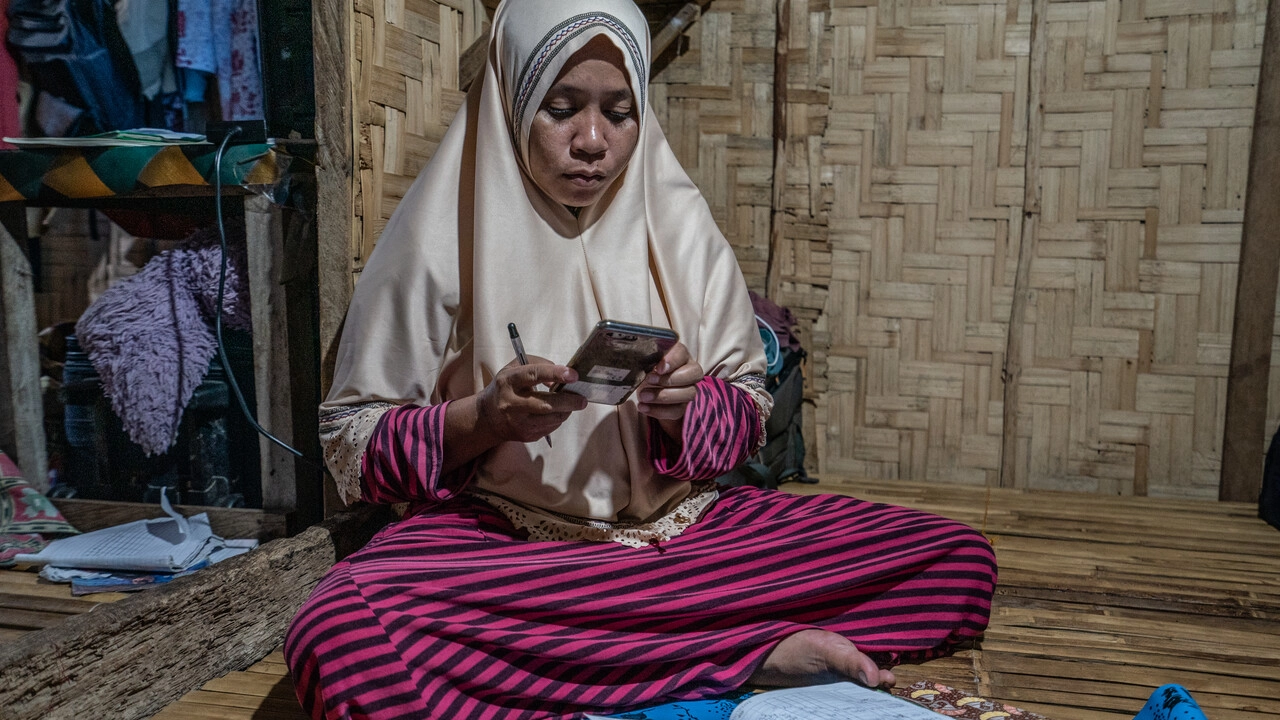 A fisher woman using her phone in Indonesia.