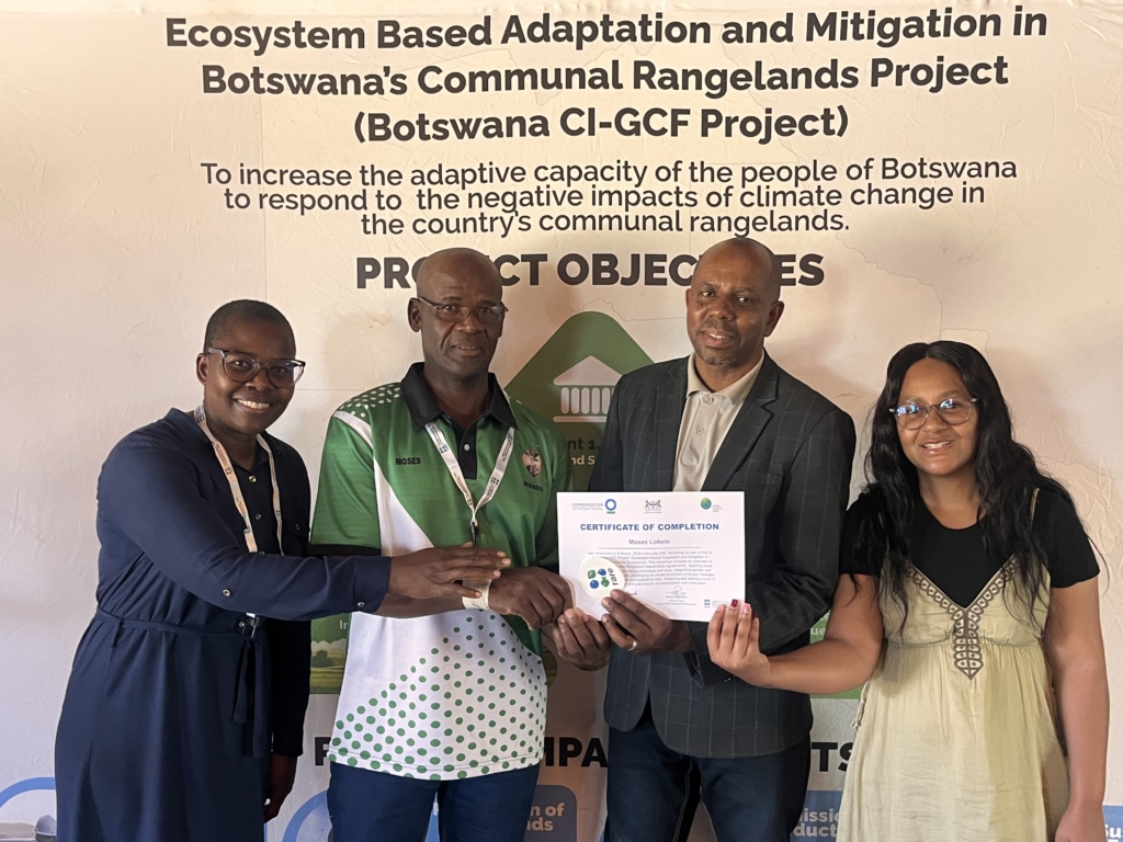 four people holding a paper certificate 