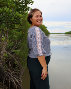 a woman standing and smiling; side profile shot