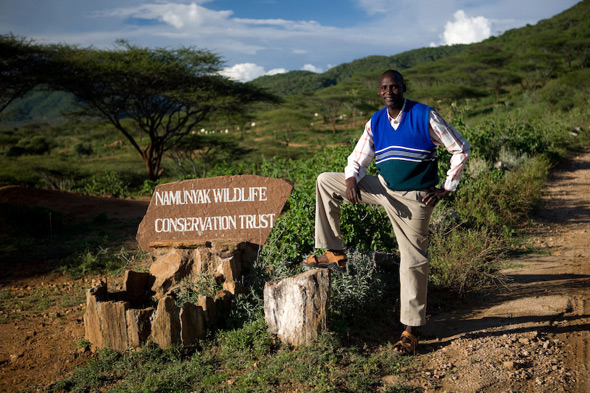 Titus Letaapo poses next to the Namunyak Conservancy sign