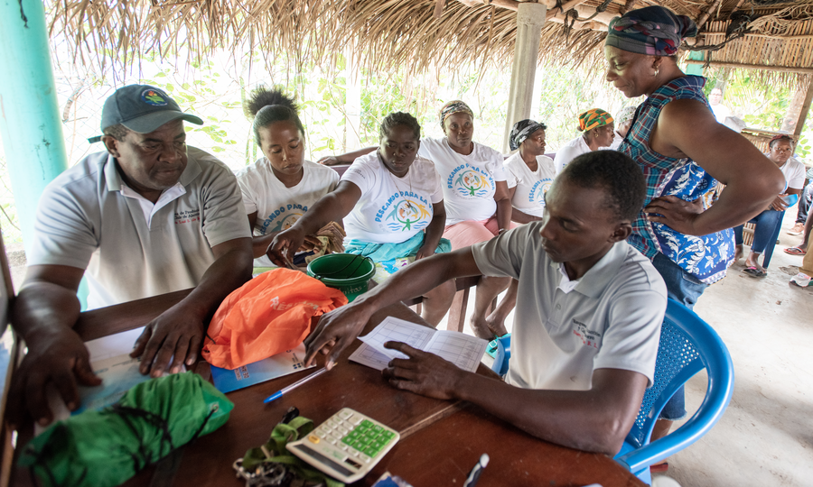 Juvencio Suazo Bernárdez (in the dark hat) leading a Nueva Luz Savings Club meeting in his Garifuna community of Cusuna. Juvencio is a Fish Forever champion, community leader, tea and casava farmer, and turtle conservationist.
