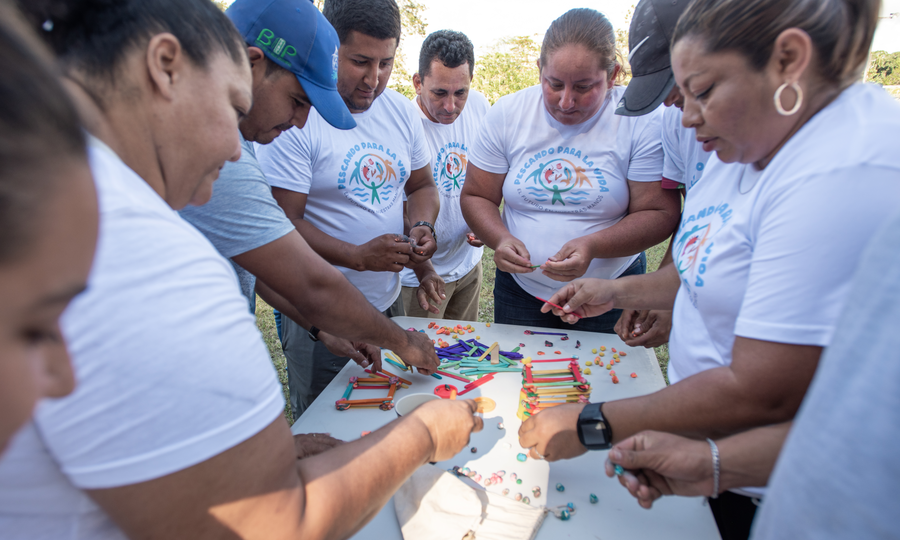 A hands-on, informational workshop with community members in Chivana to teach them about savings clubs and the importance of saving money. Presenters explain the methodology of savings clubs and learn about the participants' dreams and goals.