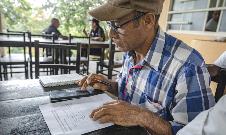 Local farmer Eider calculating data they collected during a community workshop organized by Rare.